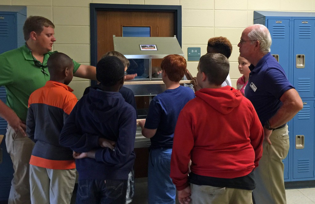 FFA advisor, Rick Burrell looks on as Heath highlights nest features.